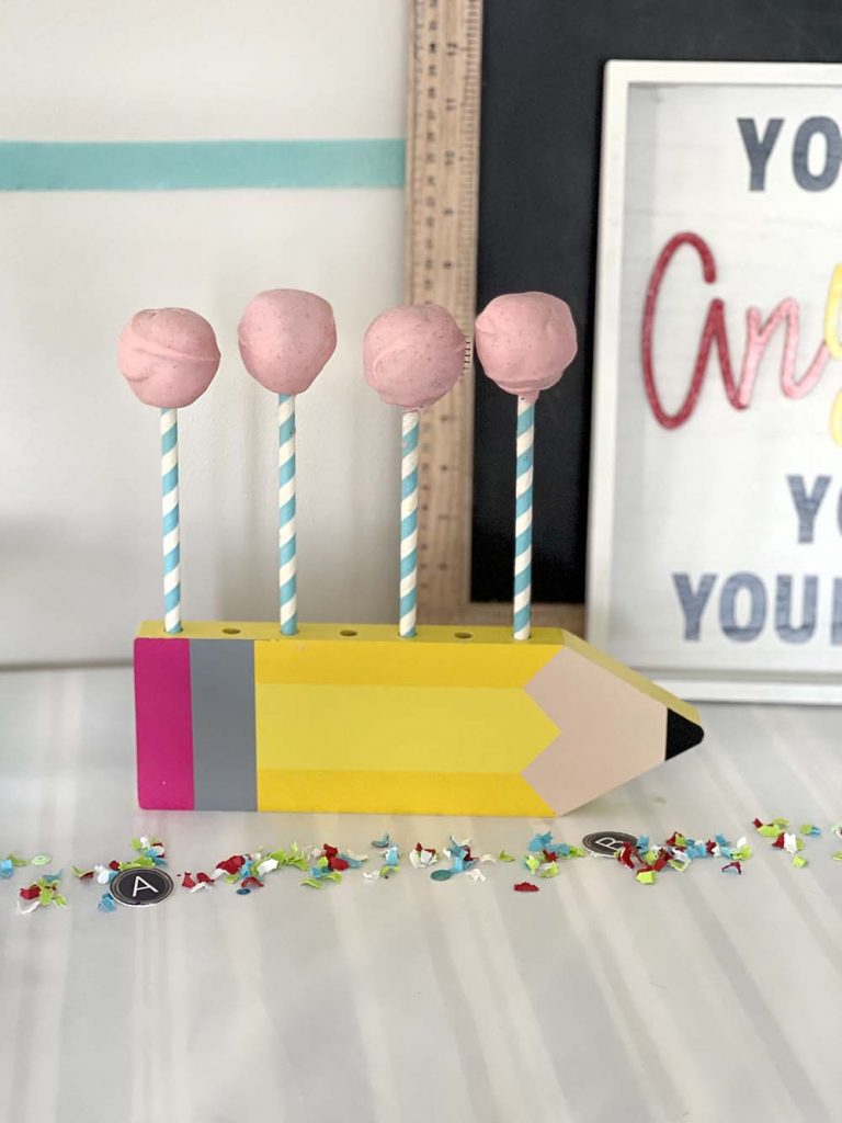 dipped chocolate date balls drying on pencil stand for back to school party
